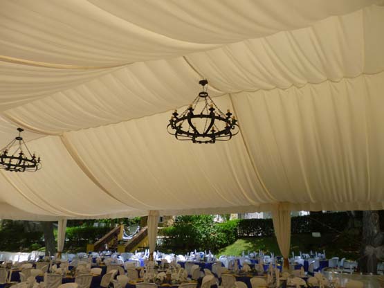 Lámparas rústicas colocadas bajo una carpa habilitada para la celebración de una boda en el Huertecillo